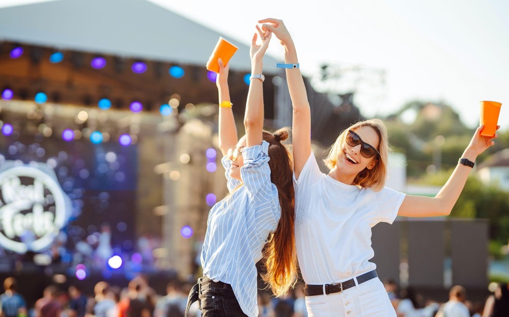 Two young women drinking and having fun at a concert